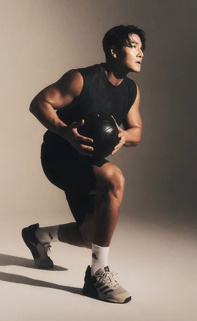 Kim Jong-guk holding a medicine ball mid-workout